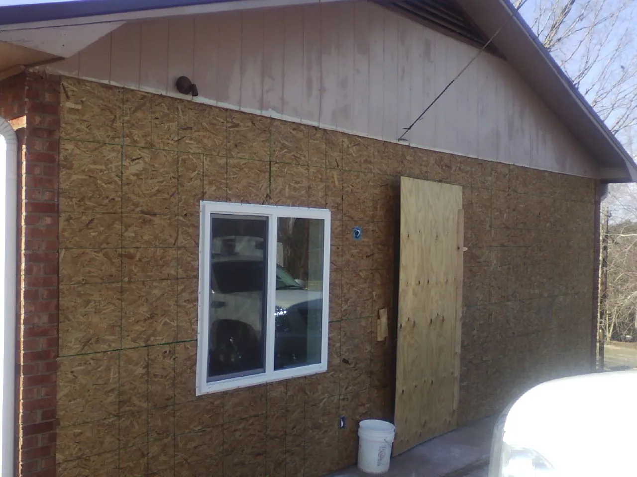 OSB sheathing on a garage addition wall before siding in Bally