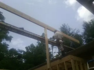 Carpenter setting a ridge beam over a new addition frame — Ice Dam Removal by Roofing Brothers in Bally