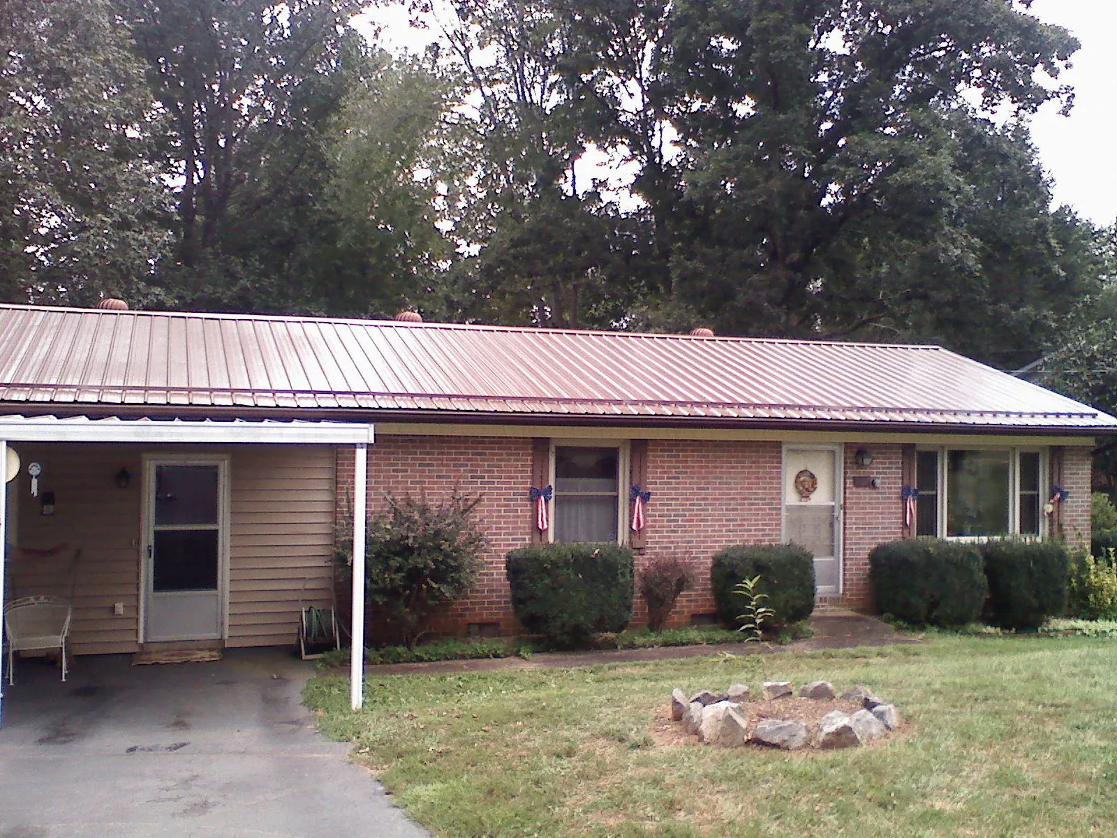 Bronze metal roof and carport on a brick ranch home — Roof Repair work by our crew in Bally